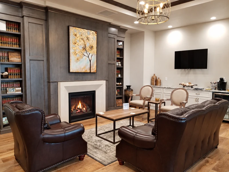 Light concrete fireplace surround set into dark wood cabinetry in a furnished room